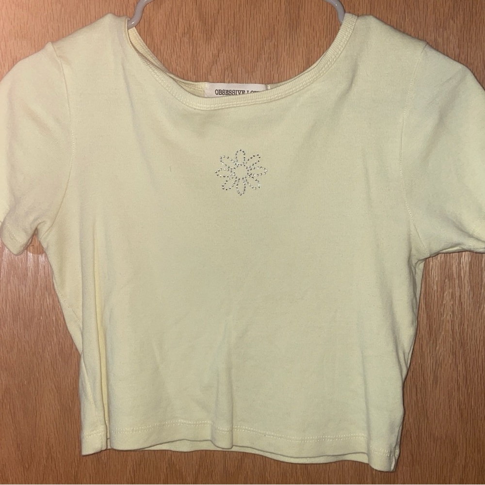 light yellow baby tee with gem shaped daisy in the middle!